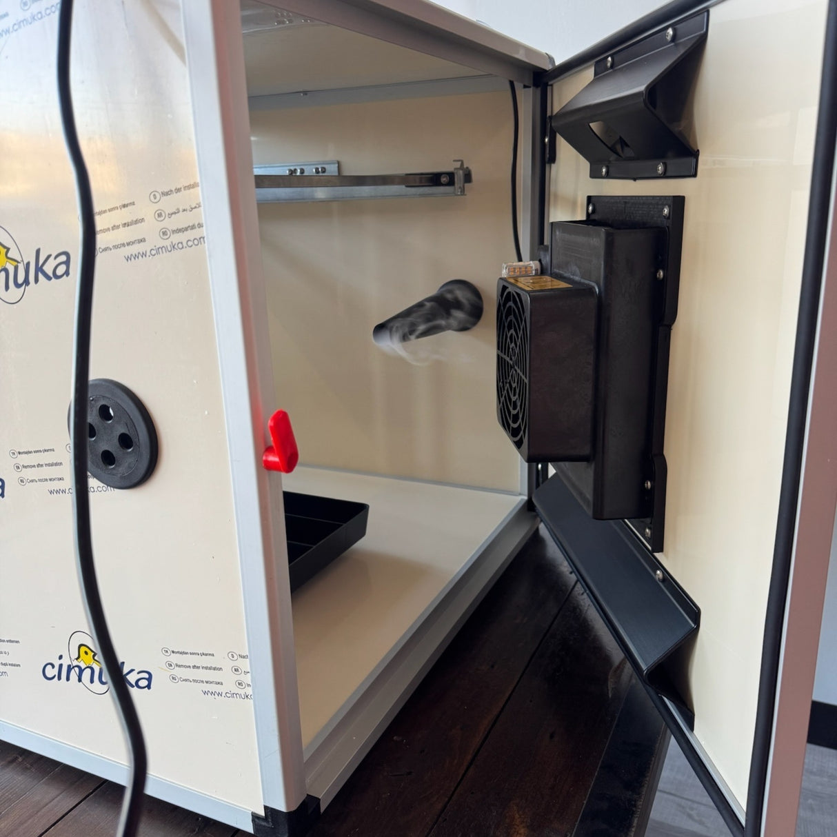 Hatching Time. Queen bee incubator back door can be seen open with humidifier next to it, producing vapor to distribute throughout the incubator.