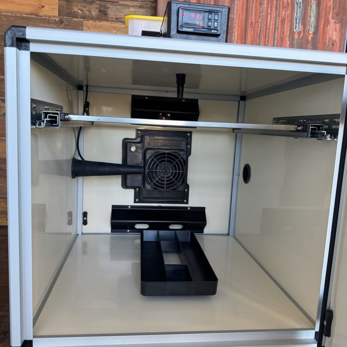 Hatching Time. Queen bee incubator interior close up with back door closed, showing humidity tray and fan