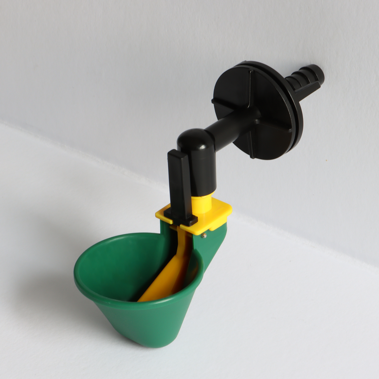 Top view of auto-fill poultry drinker cup with float valve and yellow trigger paddle for chicken coop hydration setu