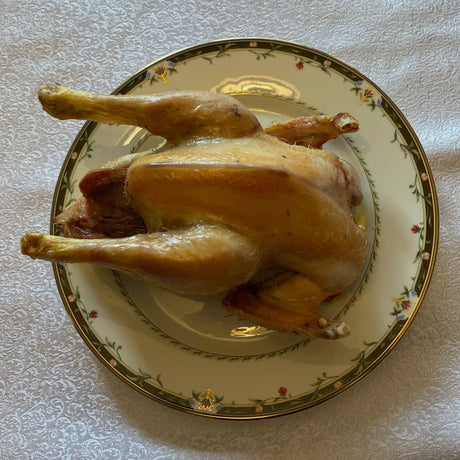 Whole roasted chicken served on a decorative plate