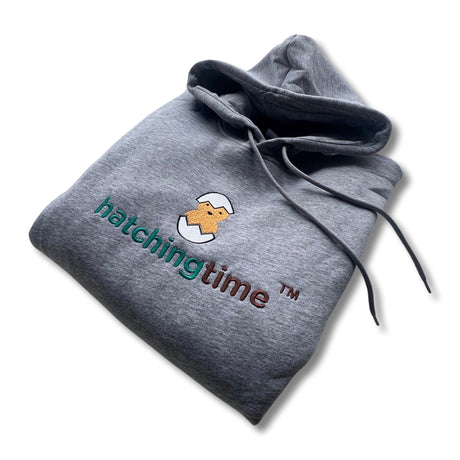 Hatching Time hooded sweatshirt grey can be seen. Hatching Time Logo can be seen.