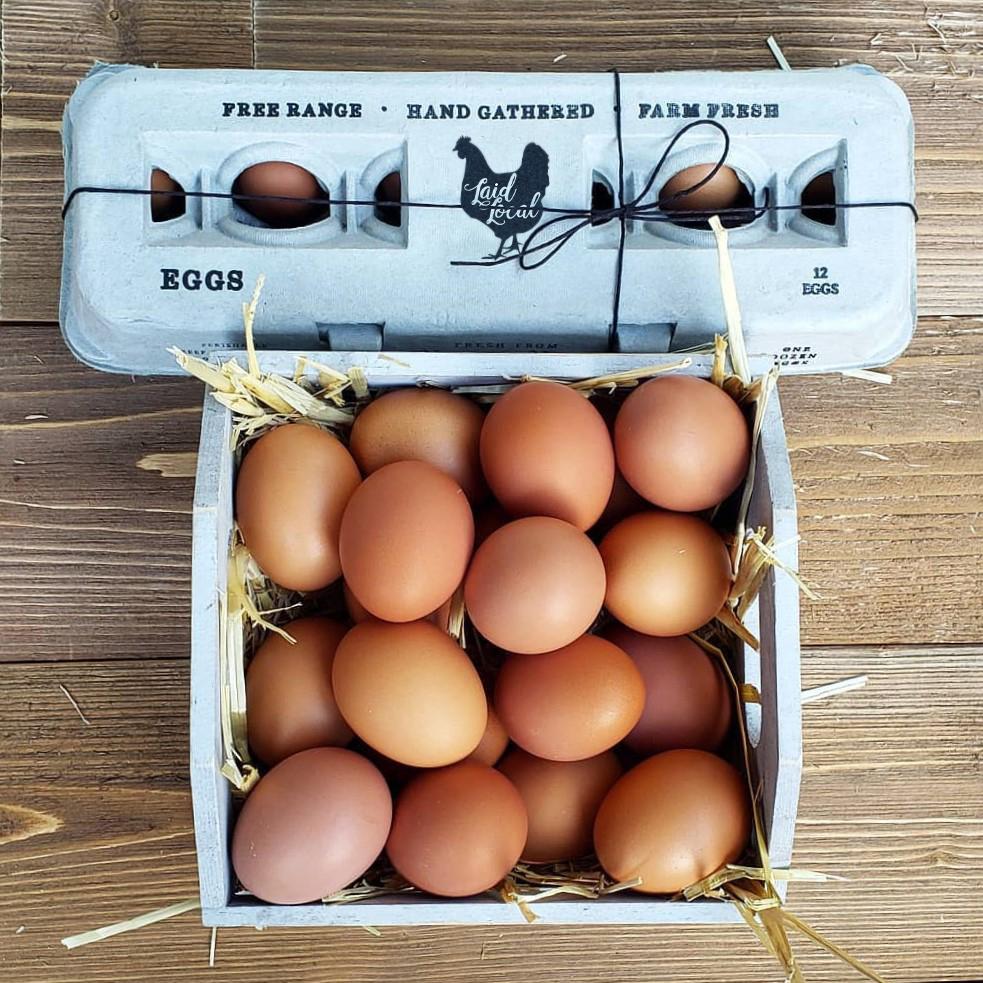 Hatching Time Henlay Egg Carton pre-marked with free range, hand gathered, farm fresh and laid local branding in front of a basket of eggs.