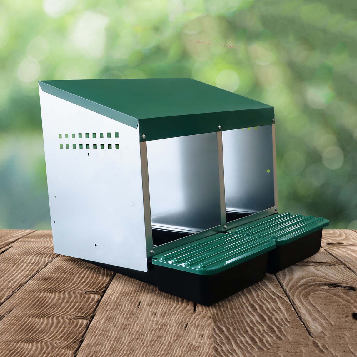 EggHouse galvanized 2-bay nesting box with green roof and roll-out trays displayed on wooden surface with natural outdoor background