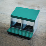 EggHouse galvanized 2-bay nesting box with green roof and dual roll-out trays placed on wooden floor for backyard coop setup
