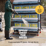 Person power washing a stacked plastic quail breeding cage outdoors