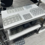 Hatching Time. Clear plastic egg cartons on shelves in warehouse.