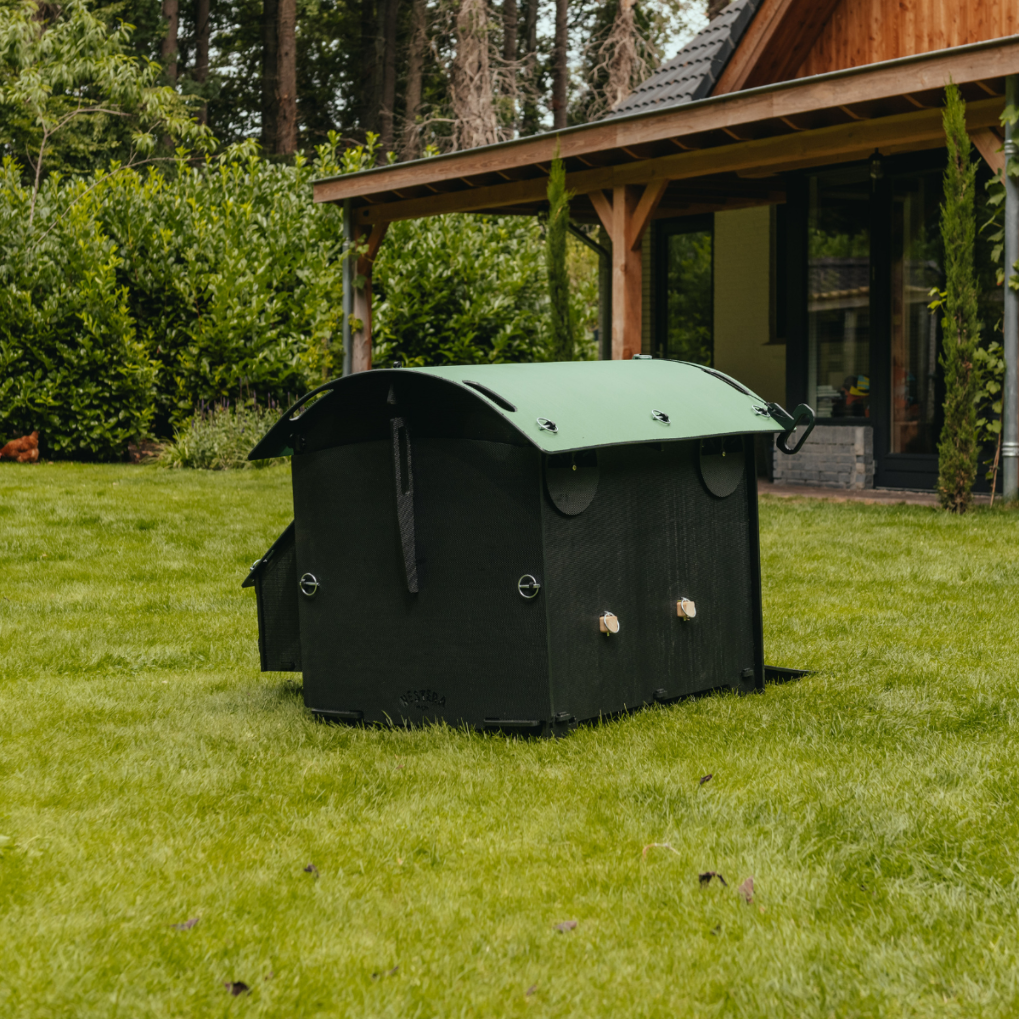 Hatching Time Nestera. Medium Raised coop can be seen in image on grass. Nesting box is on side connected to chicken coop, with lifting door for easy egg access. Roof of coop is slanted to prevent roosting.