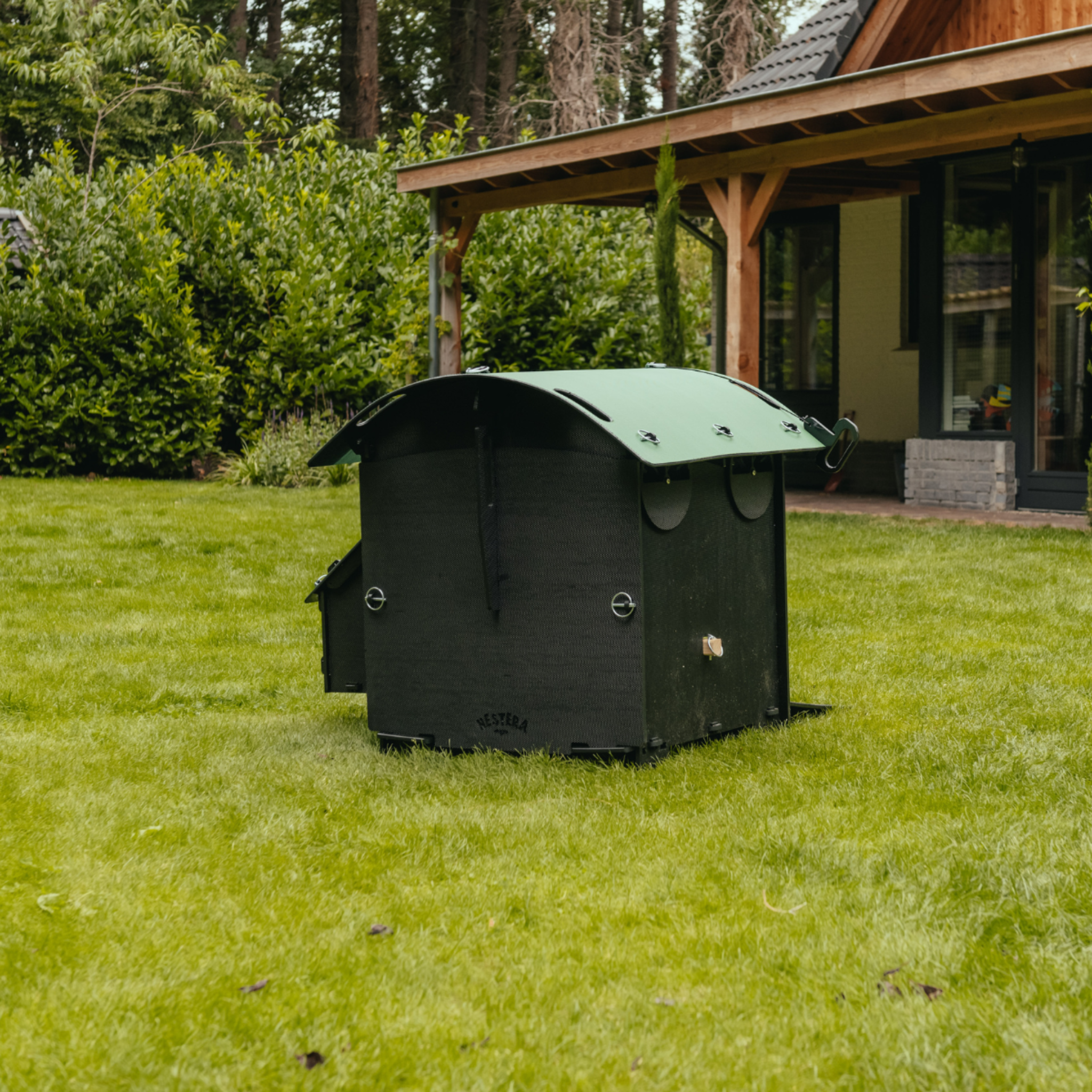 Hatching Time Nestera. Small coop can be seen in image on grass from behind. Nesting box is on side connected to chicken coop, with lifting door for easy egg access. Roof of coop is slanted to prevent roosting.