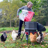 Hatching Time Coopworx 80 lb feeder silo can be seen in image being filled by a woman surrounded by chickens.