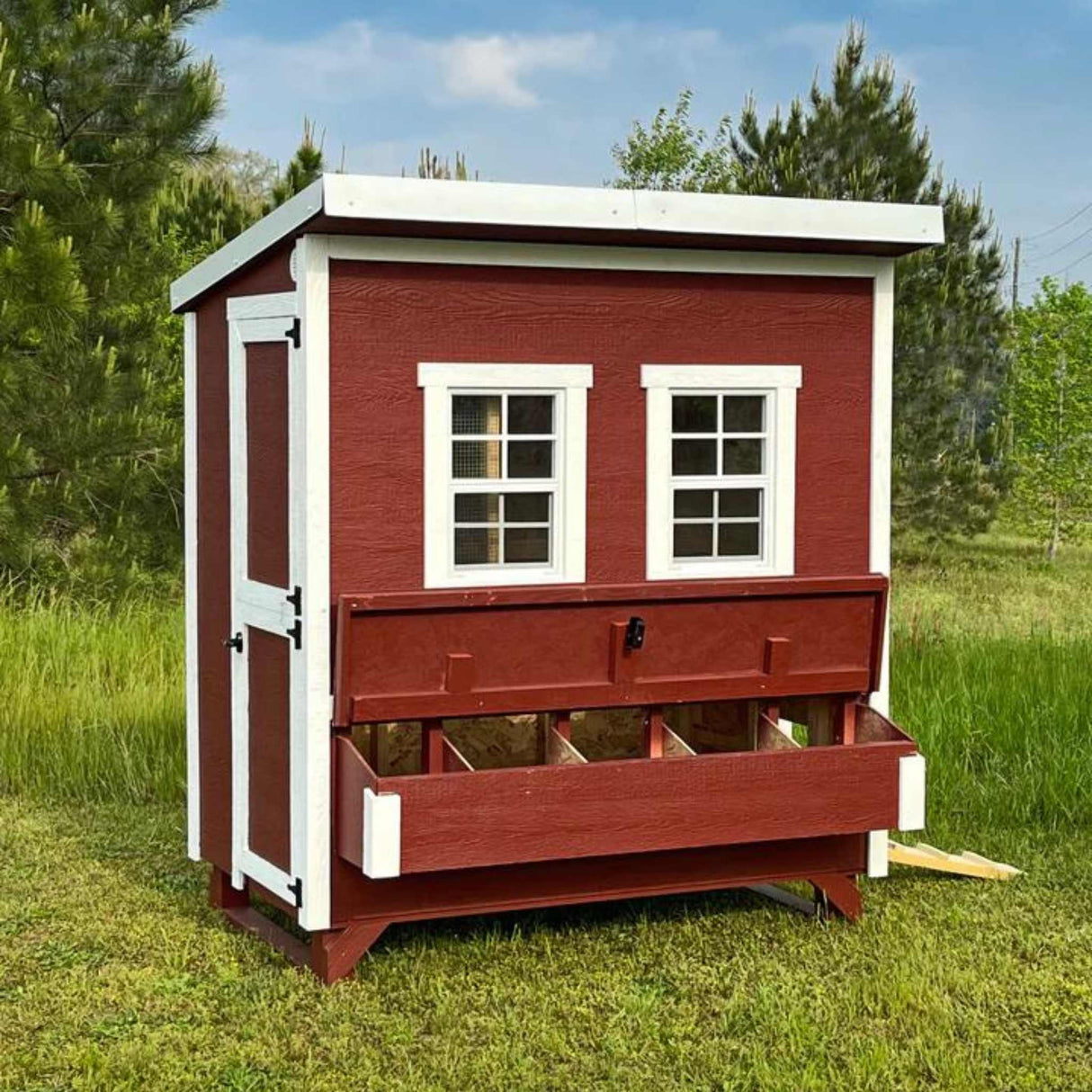 Hatching Time OverEZ. Walk-in chicken coop can be seen on grass from front with 2 windows and nesting box on front with open lid for easy egg access.