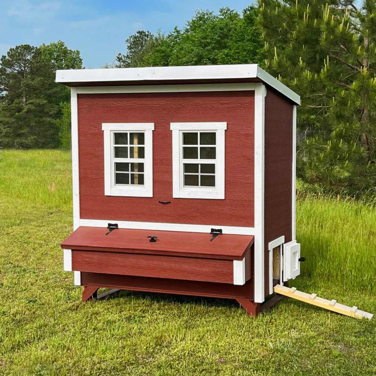 Hatching Time OverEZ. Walk-in chicken coop can be seen on grass from front with 2 windows and nesting box on front for easy egg access.