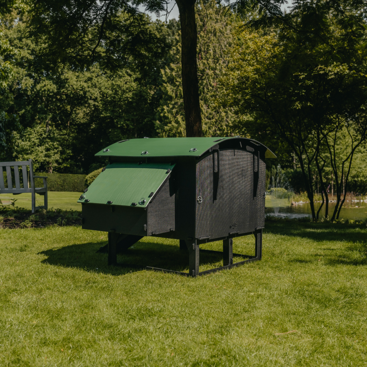 Hatching Time Nestera. Rear view large  Lodge coop can be seen in image on grass. Nesting box is on side connected to chicken coop, with lifting door for easy egg access. Roof of coop is slanted to prevent roosting.