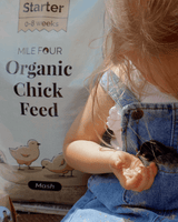 a large bag of Mile Four Starter Organic Chicken Feed Mash next to a child with a small baby chick