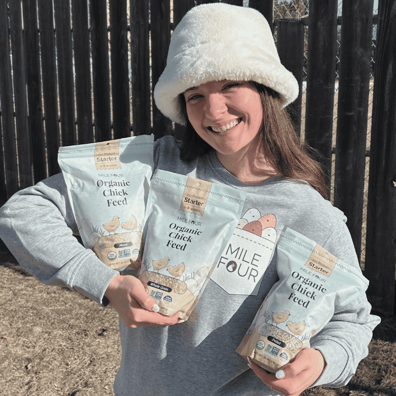 a woman holding the Mile Four Starter Organic Chicken Feed sampler peck