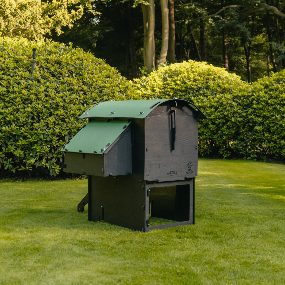 Hatching Time Nestera. Medium Raised coop can be seen from behind in image on grass. Nesting box is on side connected to chicken coop, with lifting door for easy egg access. Roof of coop is slanted to prevent roosting.