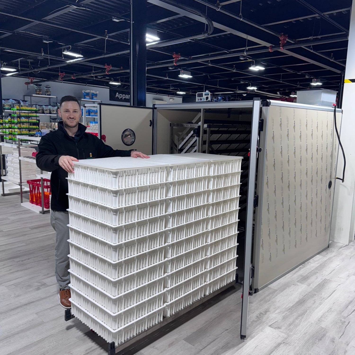 Hatching Time. T series Incubator can be seen with trolley being taken out full of hatching baskets in warehouse.