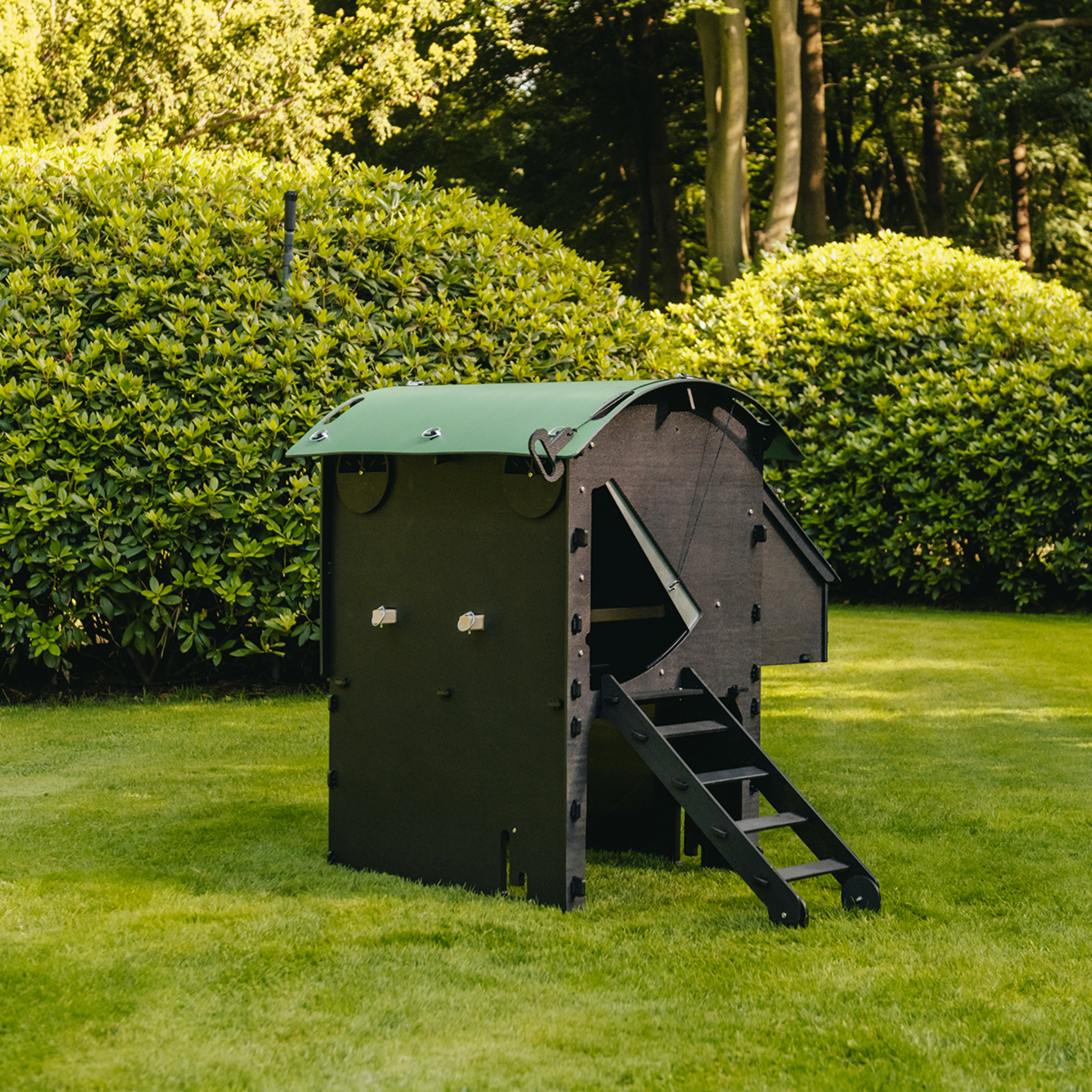 Hatching Time Nestera. Penhouse coop can be seen on grass. Steps can be for access for chickens to coop opening. Roof is rounded to prevent roosting.