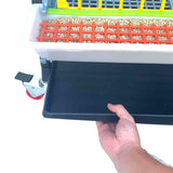 Hatching Time Cimuka 15" Grow out pen. Manure tray being pulled out of bottom of grow out pen. Feeding trough can be seen with smart feeder grill.